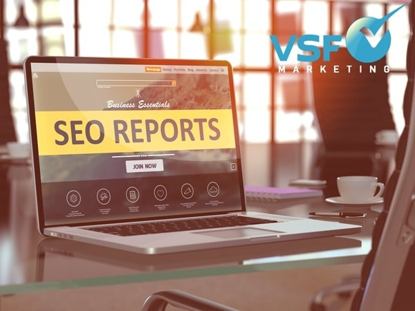 Laptop showing an SEO report dashboard with keyword rankings and traffic